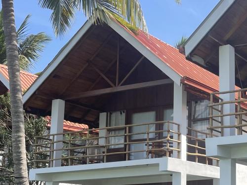 a house with a red roof and a palm tree at Kitekuda Kite Resort in Vannativillu