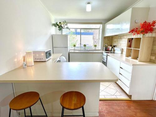 a kitchen with a large white counter and two chairs at Home in Somers in Somers