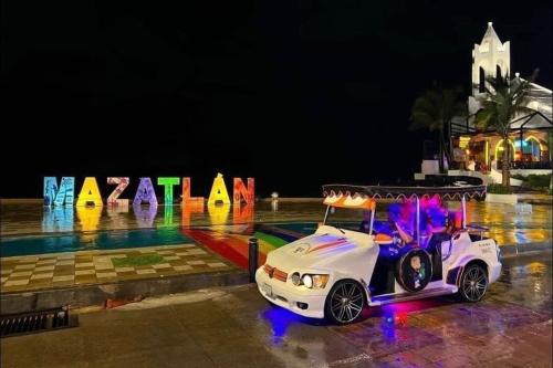 a golf cart parked in front of a sign at night at Increible departamento NUEVO en Mazatlán in Mazatlán