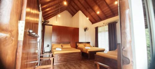 a bathroom with two beds and a shower in a room at Warahana Riverside Cottage Udawalawa in Udawalawe