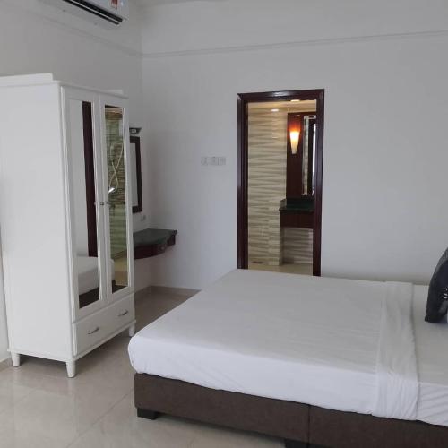 a bedroom with a white bed and a mirror at Fantastic appartment at times square Kuala Lumpur in Kuala Lumpur