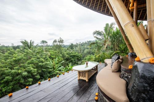 a porch of a resort with a table on a deck at Aura Svarga - Swarga House in Selat