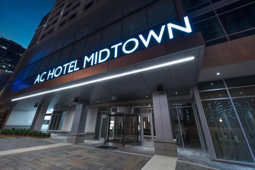 an office building with the sign for a modern midtown at AC Hotel by Marriott Atlanta Midtown in Atlanta