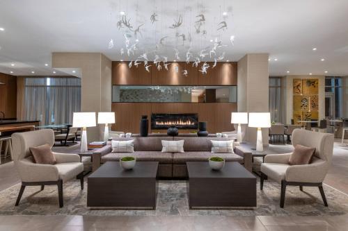 a living room with a couch and chairs and a fireplace at AC Hotel by Marriott Atlanta Midtown in Atlanta