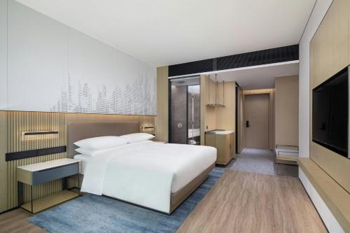 une chambre avec un lit blanc et une télévision à écran plat dans l'établissement Courtyard by Marriott Beijing Changping, à Pékin