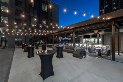 a rooftop patio with tables and chairs and lights at AC Hotel by Marriott Atlanta Midtown in Atlanta