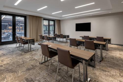 a conference room with tables and chairs and a flat screen tv at AC Hotel by Marriott Atlanta Midtown in Atlanta