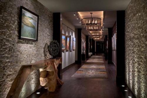a hallway with a stone wall and a long hallway with a table at Andell Inn in Kiawah Island