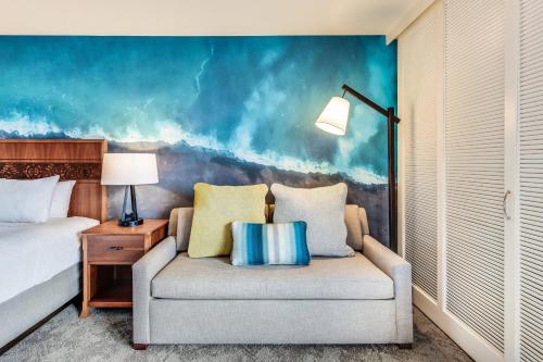 a bedroom with a bed and a couch and a chair at Courtyard by Marriott King Kamehameha's Kona Beach Hotel in Kailua-Kona