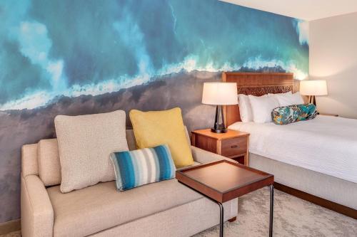 a hotel room with a couch and a bed at Courtyard by Marriott King Kamehameha's Kona Beach Hotel in Kailua-Kona