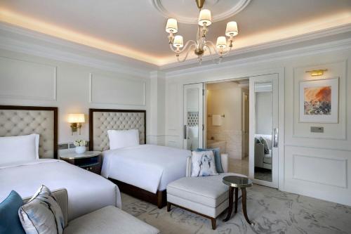 a hotel room with two beds and a couch at The Ritz-Carlton, Amman in Amman