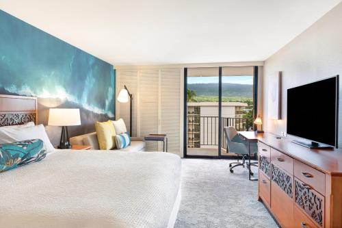 a hotel room with a bed and a flat screen tv at Courtyard by Marriott King Kamehameha's Kona Beach Hotel in Kailua-Kona