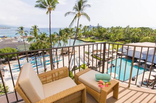 a balcony with a view of the pool and the ocean at Courtyard by Marriott King Kamehameha's Kona Beach Hotel in Kailua-Kona