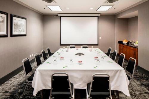 a conference room with a table and chairs and a projector screen at Courtyard by Marriott Boston Brookline in Brookline