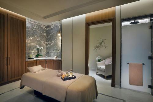 a bedroom with a bed and a bath room at The Ritz-Carlton, Amman in Amman