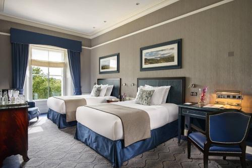 a hotel room with two beds and a window at The Shelbourne, Autograph Collection in Dublin