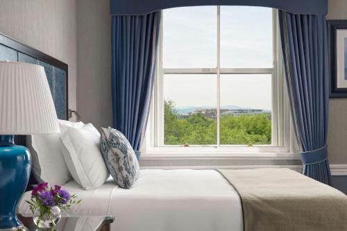 a bedroom with a bed with a large window at The Shelbourne, Autograph Collection in Dublin