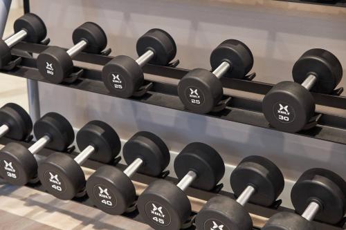 a row of dumbbells in a gym at AC Hotel by Marriott Charlotte SouthPark in Charlotte