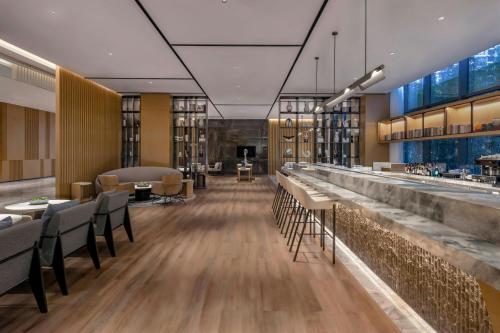 a restaurant with a bar and tables and chairs at Courtyard by Marriott Foshan Gaoming in Foshan