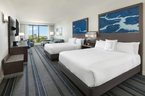 a hotel room with two beds and a desk at Courtyard by Marriott Boston Cambridge in Cambridge
