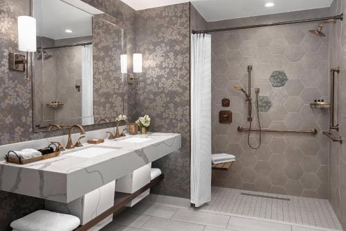 a bathroom with a large sink and a shower at The Lytle Park Hotel, Autograph Collection in Cincinnati