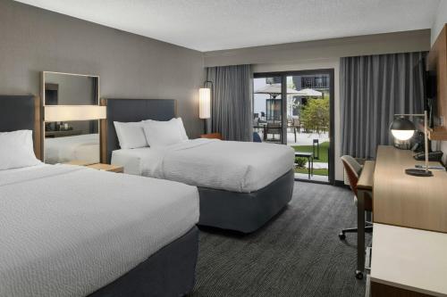 a hotel room with two beds and a desk at Courtyard Boise Downtown in Boise