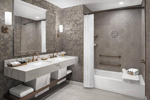a bathroom with a sink and a tub and a toilet at The Lytle Park Hotel, Autograph Collection in Cincinnati