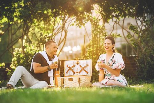 a man and a woman sitting on the grass with wine glasses at The Lytle Park Hotel, Autograph Collection in Cincinnati