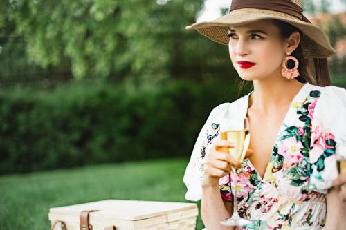 a woman in a hat holding a glass of wine at The Lytle Park Hotel, Autograph Collection in Cincinnati