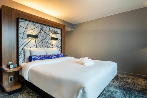 a bedroom with a large white bed with a window at Aloft Brussels Schuman in Brussels