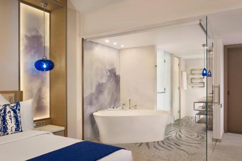 a bathroom with a tub and a bed and a sink at Paragraph Resort & Spa Shekvetili, Autograph Collection in Shekvetili