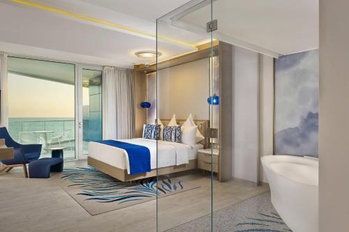 a hotel room with a bed and a bath tub at Paragraph Resort & Spa Shekvetili, Autograph Collection in Shekvetili