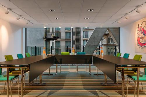 a conference room with a large table and chairs at Aloft Brussels Schuman in Brussels