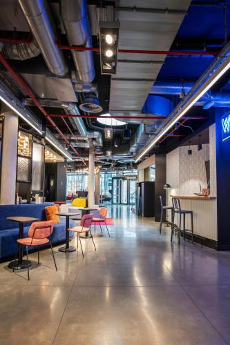 a large room with tables and chairs in a building at Aloft Brussels Schuman in Brussels