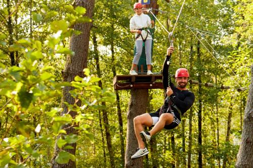 a man on a zip line in a forest at Paragraph Resort & Spa Shekvetili, Autograph Collection in Shekvetili