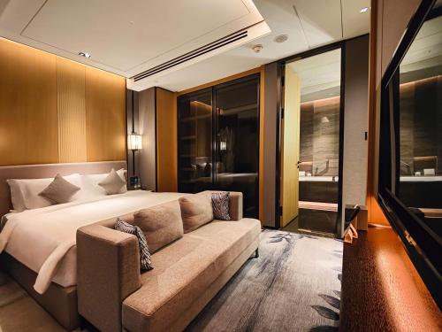 a bedroom with a large bed and a couch at Kempinski Residences Guangzhou - Free shuttle between hotel and Exhibition Center during Canton Fair & Exhibitor registration Counter in Guangzhou