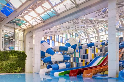 a water slide in a building with a pool at Paragraph Resort & Spa Shekvetili, Autograph Collection in Shekvetili