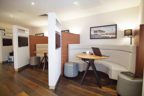a room with a bed and a table with a laptop on it at Courtyard by Marriott Glasgow Airport in Paisley