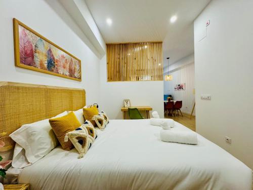 a bedroom with a large white bed with yellow pillows at LOFT 3 - Space & Conform Close To Center in Valencia