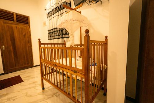 a crib in a room next to a door at Hotel Herb Garden in Udawalawe
