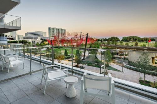 a balcony with white chairs and a view of a city at HALL Park Hotel, Autograph Collection in Frisco