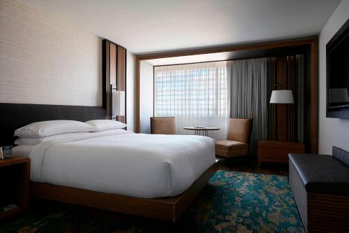 a hotel room with a large bed and a window at Charlotte Marriott City Center in Charlotte