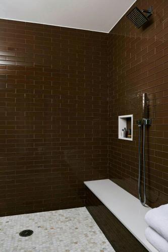 a brown tiled bathroom with a shower and a sink at Charlotte Marriott City Center in Charlotte