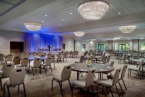 a banquet hall with tables and chairs and chandeliers at Charlotte Marriott City Center in Charlotte