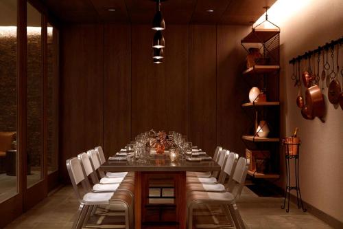 a dining room with a long table and white chairs at Charlotte Marriott City Center in Charlotte