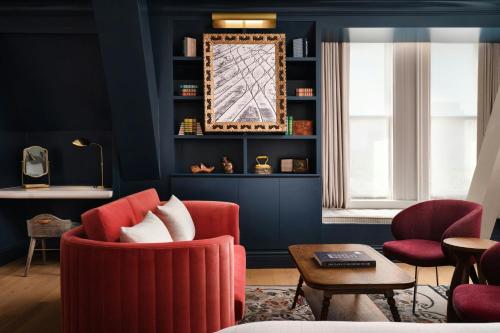 a living room with blue walls and red chairs at The Union Station Nashville Yards, Autograph Collection in Nashville