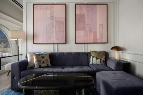 a living room with a blue couch and a table at The Union Station Nashville Yards, Autograph Collection in Nashville
