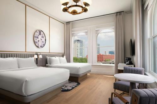 a hotel room with two beds and a window at The Union Station Nashville Yards, Autograph Collection in Nashville