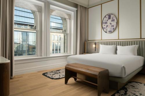 a bedroom with a white bed and two windows at The Union Station Nashville Yards, Autograph Collection in Nashville