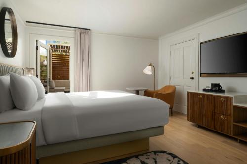 a bedroom with a large white bed and a television at The Union Station Nashville Yards, Autograph Collection in Nashville